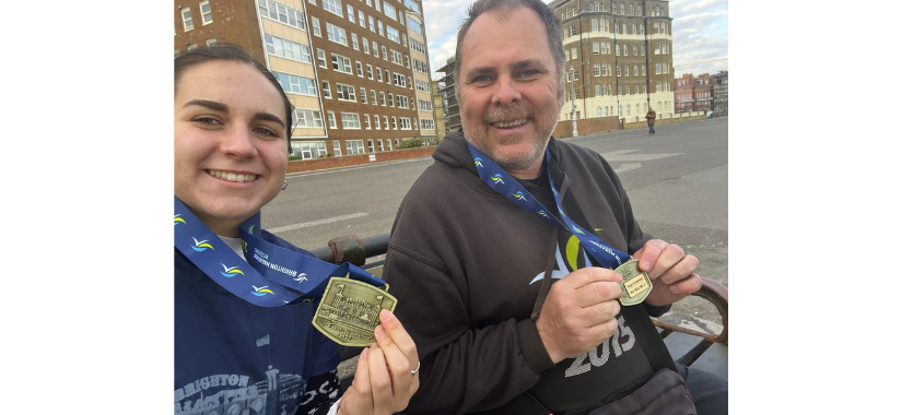 Two buddies holding their running medals