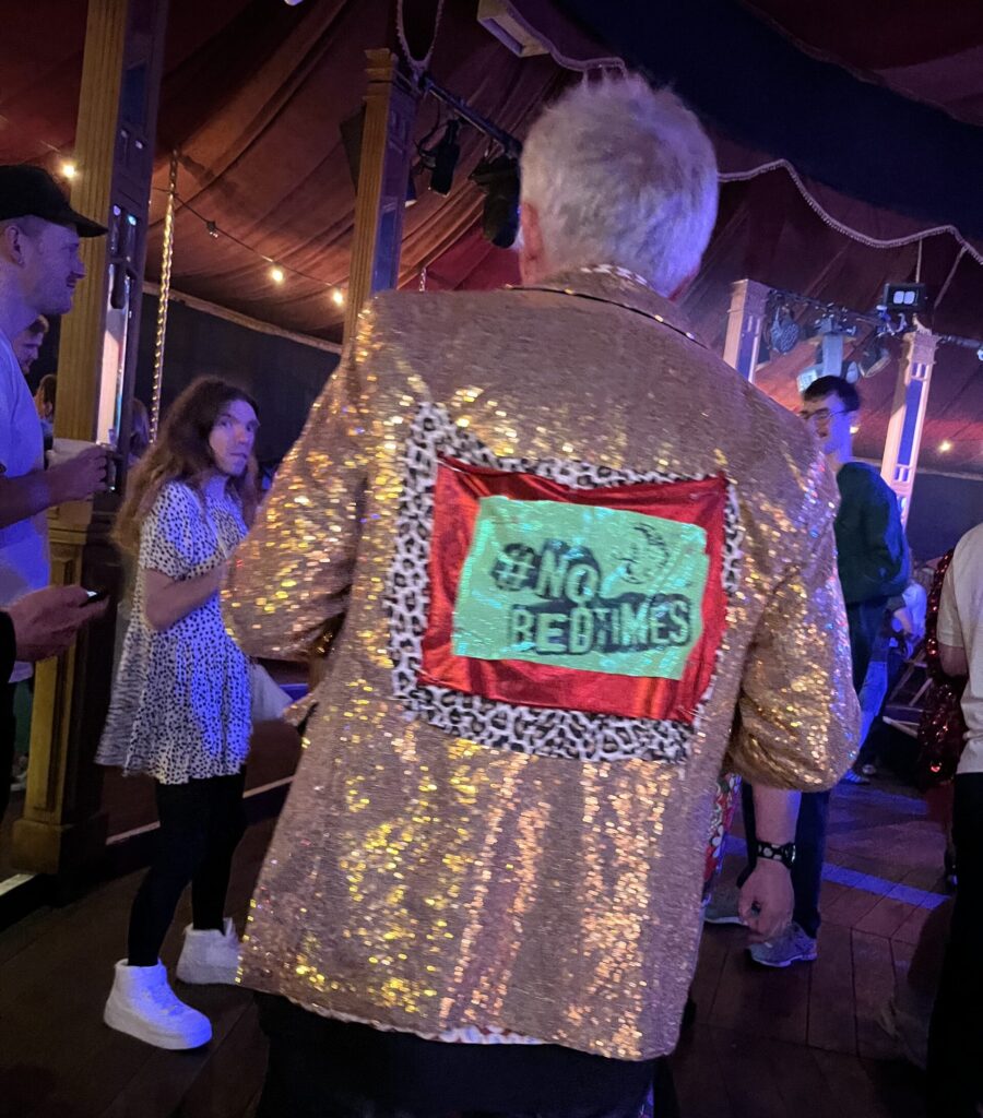 Paul, founder of Stay Up Late, out partying for disability rights. On the back of his shiny gold jacket it says #NoBedtimes.